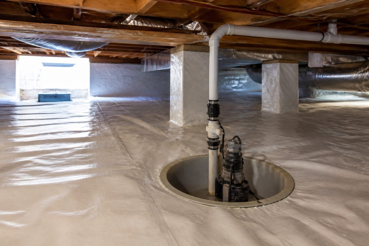 A sump basin and vapor barrier are visible in a dry, maintained residential crawl space.