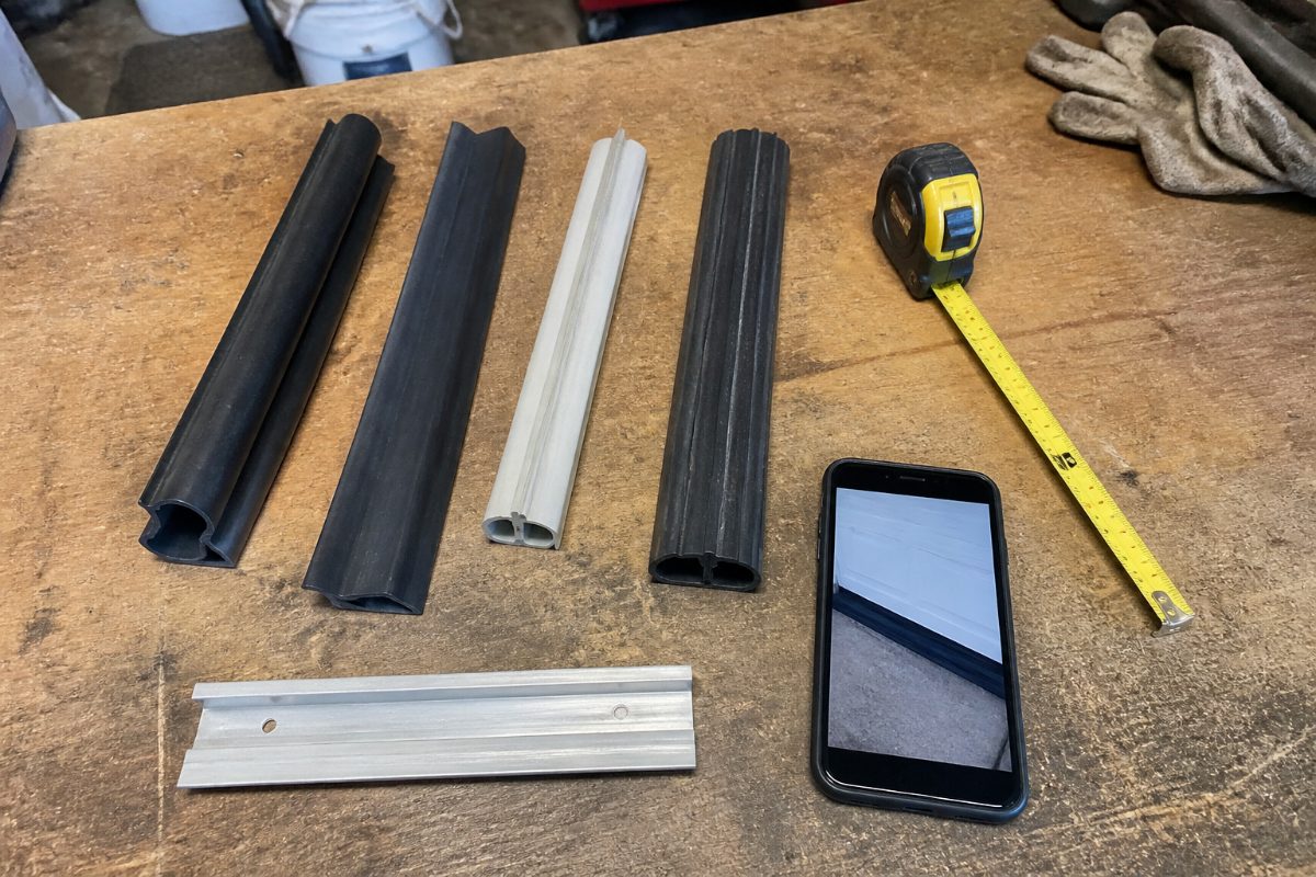 Unbranded garage door seal samples and a retainer arranged for a fit comparison.