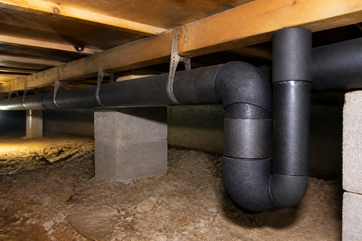 Foam sleeves protect straight sections and bends in a crawl space pipe run.