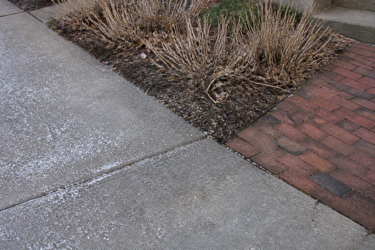Ice melt is kept on the concrete driveway and away from nearby plants and brick.